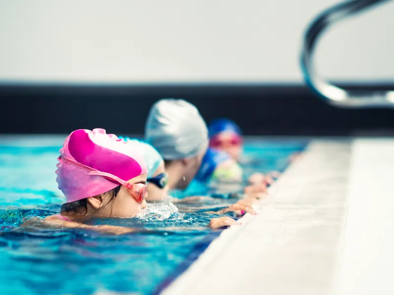 Kinder im Schwimmkurs am Beckenrand, SVV Plauen Jugendprogramm
